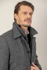 Chaquetón de lana color gris con pechera desmontable, cuello solapa y cierre frontal con botones y cremallera.