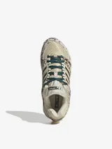 Championes Adidas Adistar Control 5 W, con diseño de running inspirado en los años 2000. Combinan tonos beige, marrones y detalles estampados tipo animal print con efecto de pelo, cordones verde oscuro y las icónicas tres tiras de la marca en los laterales.
