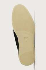 Mocasín casual de hombre confeccionado en piel con acabado serraje en color beige, con detalle de bordón en el empeine y suela fina al tono.