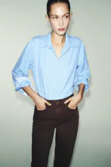 Jeans de tiro alto con corte mom fit, cinco bolsillos y cierre frontal con cremallera y botón.