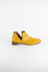 Botin de cuero con acabado grabado efecto avestruz, diseño con aberturas laterales y taco bajo cuadrado.