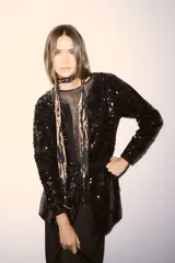 Tapado negro de corte recto completamente cubierto de lentejuelas, con mangas largas y cierre frontal. Presenta un diseño elegante y brillante ideal para eventos nocturnos.