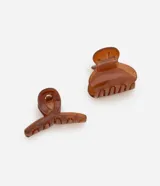 Set de dos pinzas para el pelo color marrón translúcido, una con forma de media luna y otra redondeada.