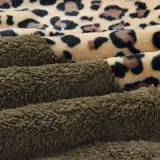 Campera tipo polar con cierre frontal, diseño combinado con estampado animal print en la parte superior y tejido de peluche blanco en la parte inferior. Cuenta con capucha con cordones ajustables y dos bolsillos frontales.