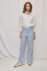 Pantalón de pierna ancha y tiro medio con diseño de rayas verticales blancas y azules. Cuenta con bolsillos delanteros amplios y cierre frontal con botón y cremallera.