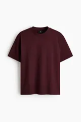 Remera de punto de algodón de peso medio color bordó, con cuello redondo ribeteado, hombros caídos y bajo recto, de corte relajado.