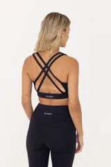 Top deportivo de sujeción media, confeccionado en poliamida y elastano. Presenta un diseño con escote redondo, breteles finos y banda elástica en la cintura para mayor ajuste y soporte. Cuenta con doble tela interna para mayor seguridad durante el entrenamiento.
