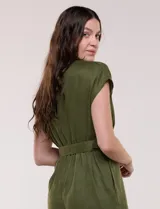 Enterito largo de lino verde militar con escote en V cruzado, mangas cortas japonesas, cintura entallada con cinturón y hebilla metálica, y pantalón de corte recto con bolsillos laterales.