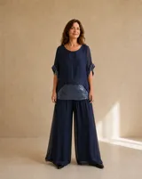 Pantalón largo azul marino de corte wide leg, con diseño fluido y doble capa de tela translúcida.