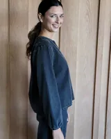 Blusa celeste de manga larga con escote en V y detalle bordado en el cuello.