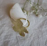 Anillo dorado con forma de flor de hibisco con textura arrugada.