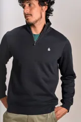 Buzo de cuello alto con cierre frontal parcial, manga larga y puños acanalados. Presenta un diseño liso en color negro con el logo de la marca bordado en el pecho.