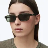 Lentes de sol modelo Kya, de montura rectangular gruesa en color verde oliva y lentes polarizadas en tono verde oscuro.