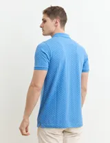 Remera polo azul marino de manga corta, con cuello y tapeta de dos botones. Presenta aberturas laterales en el dobladillo.