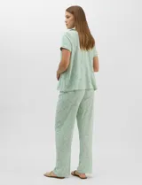Set de pijama de tres piezas en color verde menta con estampado floral sutil, compuesto por una camisa de manga corta con botones, una musculosa básica y un pantalón largo de corte recto con cordón ajustable en la cintura.