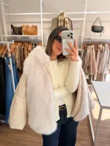 Campera puffer oversize color marrón, con paneles frontales y traseros de pelo sintético suave. Presenta mangas acolchadas, cierre frontal y bolsillo con cierre en la manga.