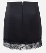 Short pollera de satén negro con acabado brillante, corte ajustado y detalle de encaje floral con transparencia en el ruedo. Cuenta con cierre invisible en la parte trasera.
