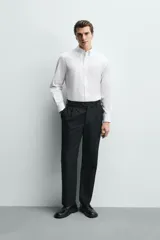 Camisa regular fit de algodón con diseño de rayas finas celestes y blancas. Cuenta con cuello abotonado, manga larga con puños abotonados y cierre frontal de botones.