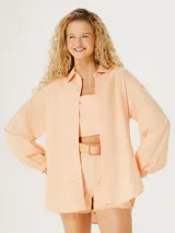 Camisa oversize color naranja con cuello clásico y mangas largas con puños elásticos.