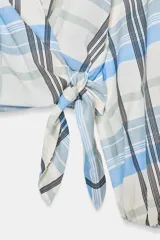 Camisa de cuello solapa y escote en pico, con diseño de cuadros en tonos azules, blancos y verdes. Presenta cierre frontal cruzado con lazada lateral y mangas largas con puños elásticos.