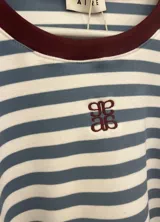 Pijama set compuesto por remera de manga larga y pantalón a rayas celestes y blancas con detalles en color bordo.