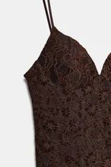 Vestido corto de encaje color marrón, con escote corazón, tirantes finos ajustables y detalle de volado en el ruedo.