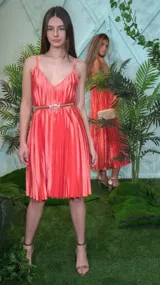 Vestido corto color salmón, con breteles finos, escote en V, falda plisada y cinturón dorado con hebilla brillante.