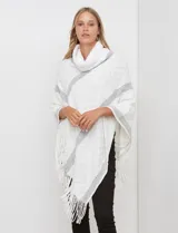 Poncho tejido Barrington color blanco con diseño de rombos en relieve y franjas diagonales grises. Posee cuello alto de tejido afelpado (velour) blanco y terminación con flecos en el ruedo.