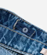 Pantalón de jeans de tiro alto, color celeste desgastado, modelo wide leg (pierna ancha) con cierre y botón metálico.