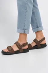 Sandalias negras de tiras ajustables con cierre de velcro, suela plana y diseño cómodo para uso diario.