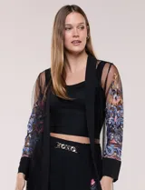 Cardigan tipo kimono largo de tul blanco semitransparente, con frente abierto y mangas largas. Presenta vistosos bordados florales multicolor en mangas, dobladillo y laterales.