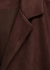 Chaqueta de efecto piel color marrón con cuello de solapa, diseño recto y detalle de flecos en la parte trasera y mangas.