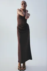 Vestido midi de escote recto sin tirantes, color marrón, con diseño semitransparente en la sección del abdomen y detalle drapeado en la falda. Cuenta con cierre lateral.