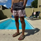Short de baño negro con cintura elástica y cordón ajustable bicolor. Presenta un parche circular con logo en la parte inferior de la pierna.
