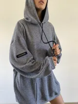 Hoodie oversize de tejido de punto con textura, color azul grisáceo, con capucha, cordones ajustables y bolsillo frontal tipo canguro.