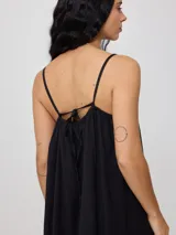 Vestido corto fucsia de algodón y lino, con breteles finos y escote recto con lazo ajustable.