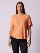 Remera blanca texturada con cuello redondo y mangas cortas con dobladillo. Detalle de botones en la espalda.