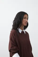 Buzo de manga larga color marrón chocolate, con silueta relajada, hombros caídos y diseño minimalista. Confeccionado en tejido suave con caída fluida.