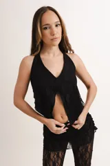 Top negro de encaje con cuello halter y abertura frontal.