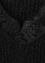 Jersey negro de punto de corte holgado, con cuello en V adornado con detalles de encaje y manga larga.