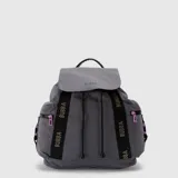Mochila Bubba modelo Mila, color gris, confeccionada en nylon. Presenta solapa superior con cierre magnético, cordón de ajuste, correas frontales decorativas con el logo de la marca y bolsillos laterales con cierres en color lila.