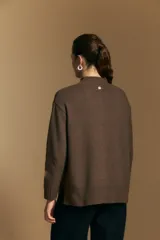 Polera de tejido de punto color blanco, con cuello alto acanalado, hombros caídos y detalle de costura vertical en el frente.