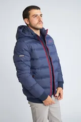 Campera puffer Mistral de hombre, color azul marino con cierre frontal y detalles en color rojo. Cuenta con capucha, puños elásticos y logo estampado en el pecho.