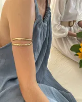 Brazalete rígido de diseño minimalista con forma de espiral, elaborado artesanalmente en bronce y alpaca maciza. Es una pieza ajustable que puede lucirse tanto en el antebrazo como en la parte superior del brazo.