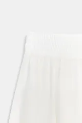 Falda midi de corte en A, color blanco, confeccionada en algodón con cintura elástica de tiro alto y forro interior a tono.