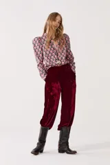 Pantalón de tiro medio-alto confeccionado en terciopelo color bordó, con diseño de piernas anchas y cintura elástica.