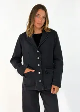 Chaqueta de gabardina color tostado con cuello de piel sintética en tono marrón, cierre frontal con botones y bolsillos delanteros con solapa.