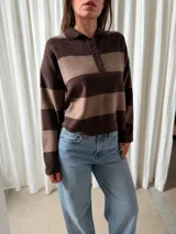 Sweater de punto con diseño de rayas horizontales anchas en tonos marrón oscuro y beige, con cuello polo y cierre frontal de botones.