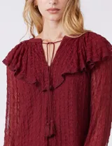 Blusa de encaje color beige, marca Cupio, con cuello a la base y escote en V con lazo de ajuste. Presenta una sobrecapa de encaje con aplique de puntilla y mangas largas de encaje floral translúcido, terminadas en puños elásticos con volado. Incluye forro interno a tono.