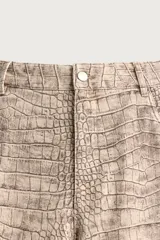 Pantalón relaxed fit de algodón con estampado animal print de cocodrilo en tonos beige y gris. Tiene diseño de cinco bolsillos, cierre frontal con cremallera y botón, y una tira con bolsillo multifunción en la pernera.